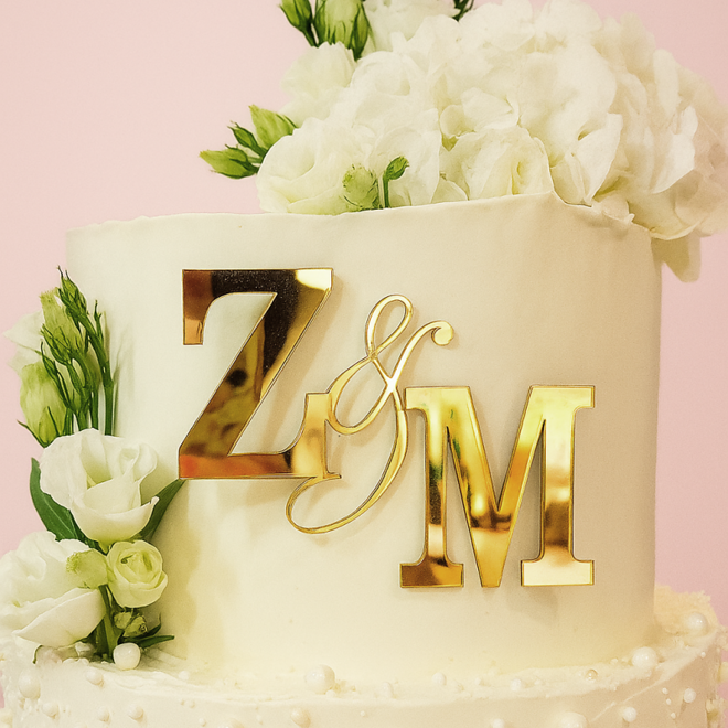 Zlaté zrkadlové iniciály na svadobnej torte s kvetmi