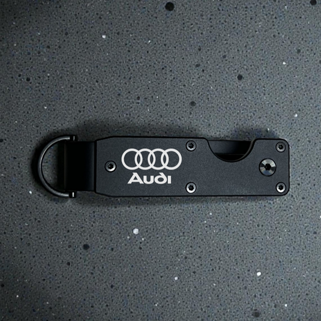 Čierny kovový organizér na kľúče s logom automobilky
